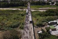 People use the Simon Bolivar International Bridge to cross between San Antonio, Venezuela, top, and Cucuta, Colombia, Friday, Aug. 5, 2022. The border has been partially closed for years by the Venezuelan government, and will gradually reopen after the two nations restore diplomatic ties when Colombia’s new president is sworn-in on Aug. 7, according to announcement in late July by Colombia’s incoming Foreign Minister Alvaro Leyva and Venezuelan Foreign Minister Carlos Faria. (AP Photo/Matias Delacroix)