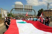 Demonstrator holds a makeshift Lebanese flag during a protest against government performance and worsening economic conditions near the presidential palace in Baabda