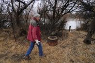 Gayna Salinas walks along her property bordering the Green River, a tributary of the Colorado River, Thursday, Jan. 25, 2024, in Green River, Utah. An Australian company and its U.S. subsidiaries are eyeing a nearby area to extract lithium, metal used in electric vehicle batteries. Salinas, whose family farms in the rural community, said she was skeptical about the project's benefits. (AP Photo/Brittany Peterson)