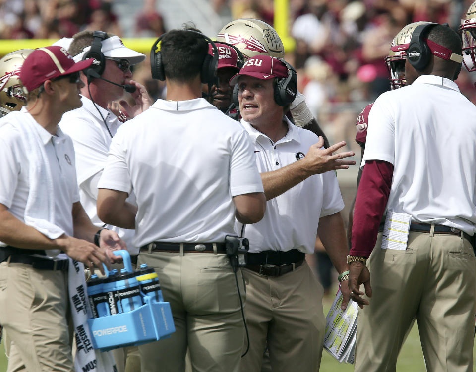 Florida State coach Jimbo Fisher, second from right, got into a verbal spat with a fan after Saturday’s loss to Louisville. (AP Photo/Steve Cannon)