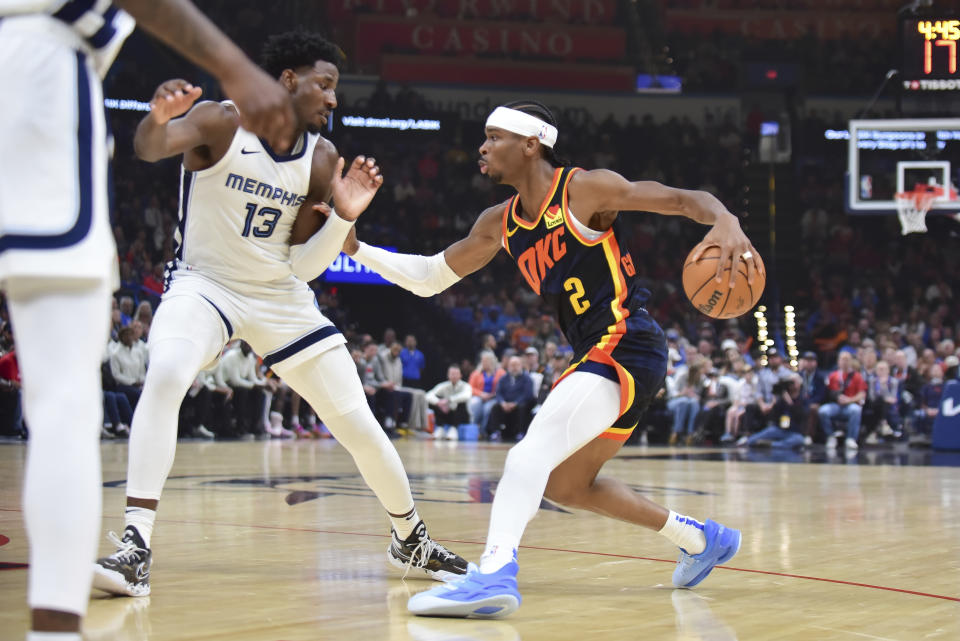 Oklahoma City Thunder guard Shai Gilgeous-Alexander (2) pushes past Memphis Grizzlies forward Jaren Jackson Jr. (13) in the first half of an NBA basketball game, Sunday, March. 10, 2024, in Oklahoma City. (AP Photo/Kyle Phillips)