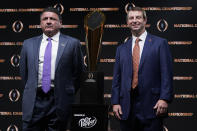 LSU head coach Ed Orgeron, left, and Clemson head coach Dabo Swinney pose with the trophy after a news conference for the NCAA College Football Playoff national championship game Sunday, Jan. 12, 2020, in New Orleans. Clemson is scheduled to play LSU on Monday. (AP Photo/David J. Phillip)