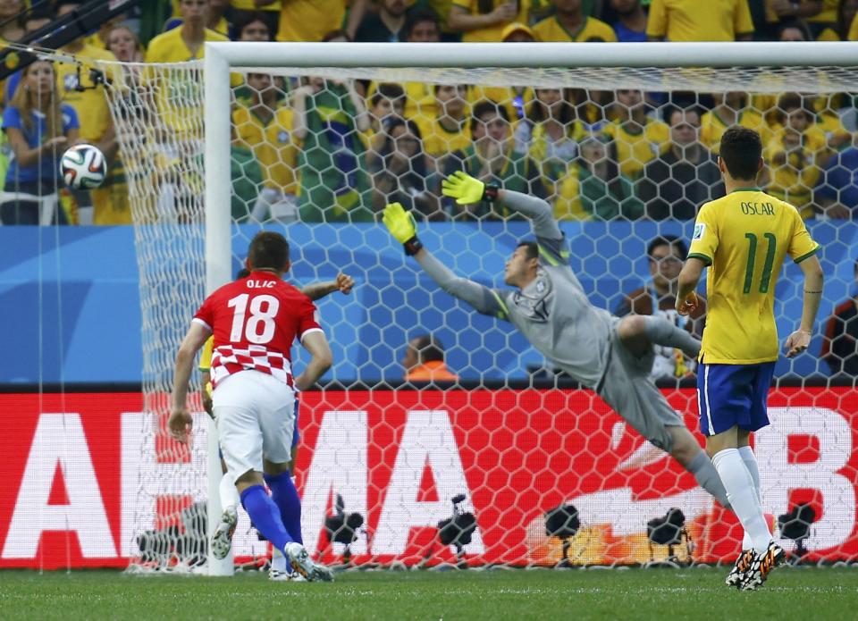 Brazil's Julio Cesar (C) jumps as he tries to save a ball during their 2014 World Cup opening match against Croatia at the Corinthians arena in Sao Paulo June 12, 2014. (REUTERS/Kai Pfaffenbach)