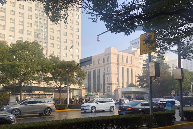 Police vehicles are seen outside a court in Shanghai