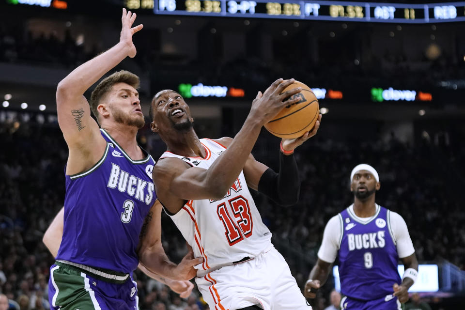 Miami Heat's Bam Adebayo (13) prepares to shoot against Milwaukee Bucks' Meyers Leonard (3) during the first half of an NBA basketball game Friday, Feb. 24, 2023, in Milwaukee. (AP Photo/Aaron Gash)