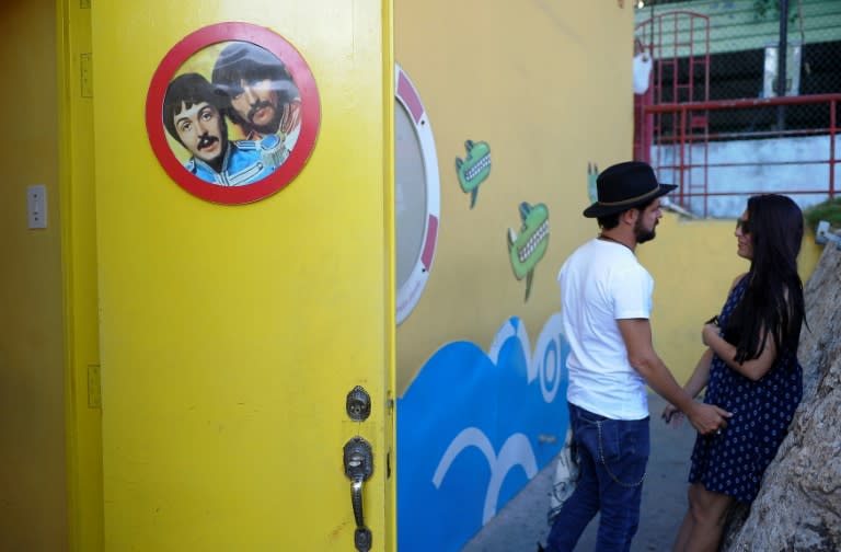 A Cuban couple stand outside the Yellow Submarine bar in Havana, on March 12, 2017