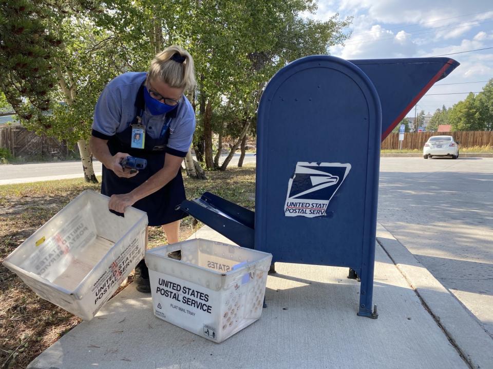 Clerk Sue Ann Gray collects mail recently from boxes outside the Leadville, Colo., post office.