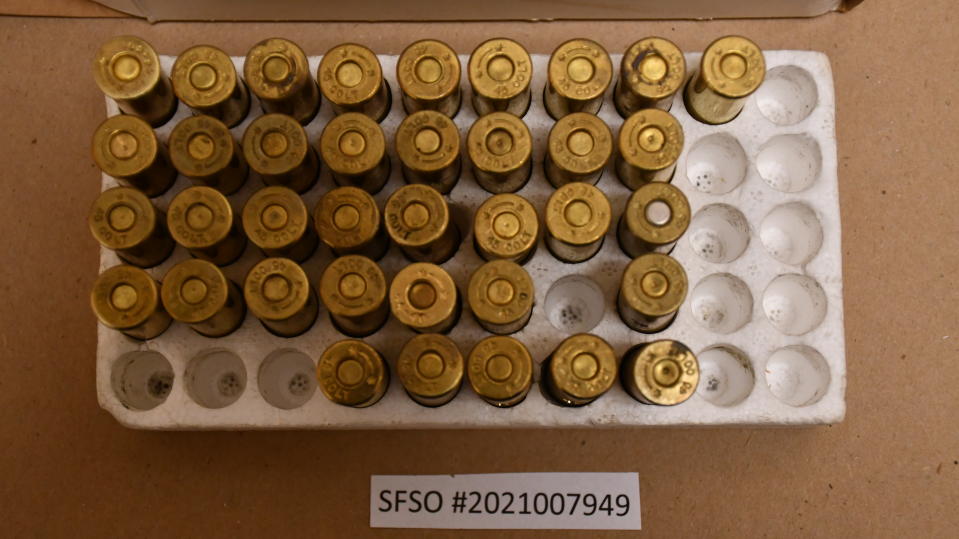 A box of dummy rounds, containing one live round with a silver primer.