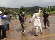 A supporter (2nd R) of Tahir ul-Qadri, Sufi cleric and leader of political party Pakistan Awami Tehreek (PAT), lifts up the hand of a Pakistan Army soldier, during the Revolution March towards the prime minister's house in Islamabad September 1, 2014. REUTERS/Akhtar Soomro