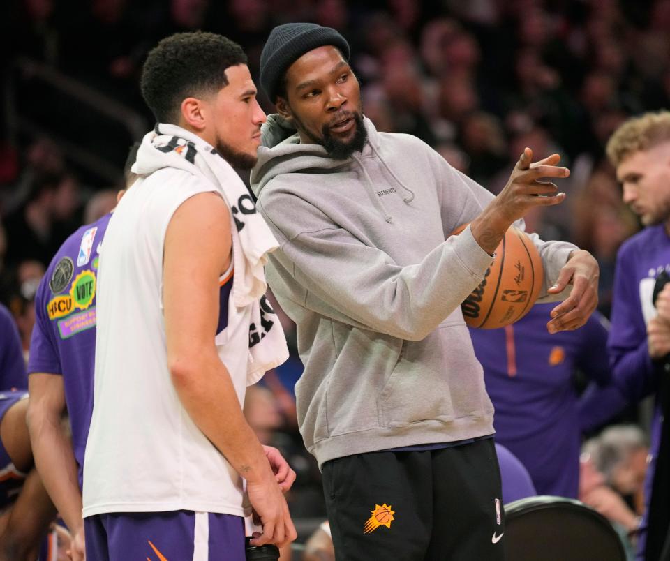 Phoenix Suns guard Devin Booker (left) and forward Kevin Durant talk during the first quarter against the Sacramento Kings at Footprint Center in Phoenix on Feb. 14, 2023.