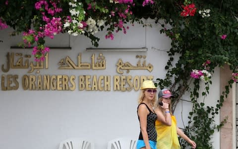 British tourists walk outside the Orange Beach hotel in in Tunisia's coastal town of Hammamet - Credit: AFP