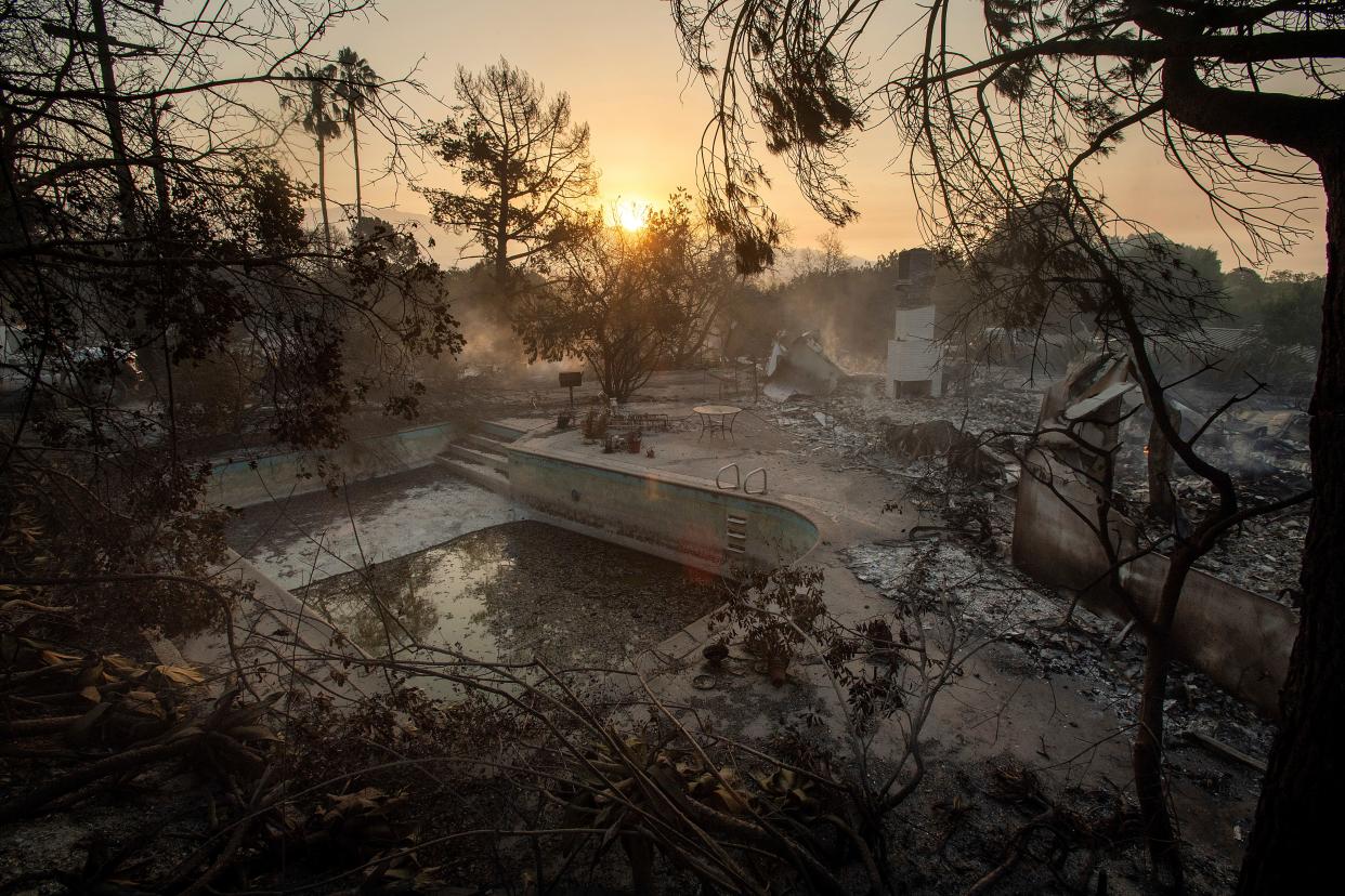 July 7, 2018: The sun rises behind a home leveled by the Holiday fire in Goleta, Calif. Evacuations were ordered as the fire edged into residential areas.