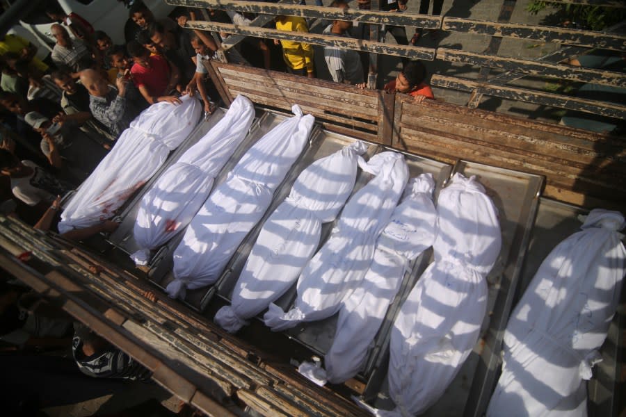Bodies of the Abu Rayash family killed in Israeli shelling are loaded on the truck at Edwin Hospital in Rafah, Gaza Strip, Thursday, Oct. 12, 2023. (AP Photo/Hatem Ali)