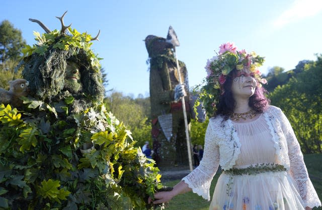 Richard and Jenni Thompson, depicting the Green Man and May Queen, in front of a giant wicker man 