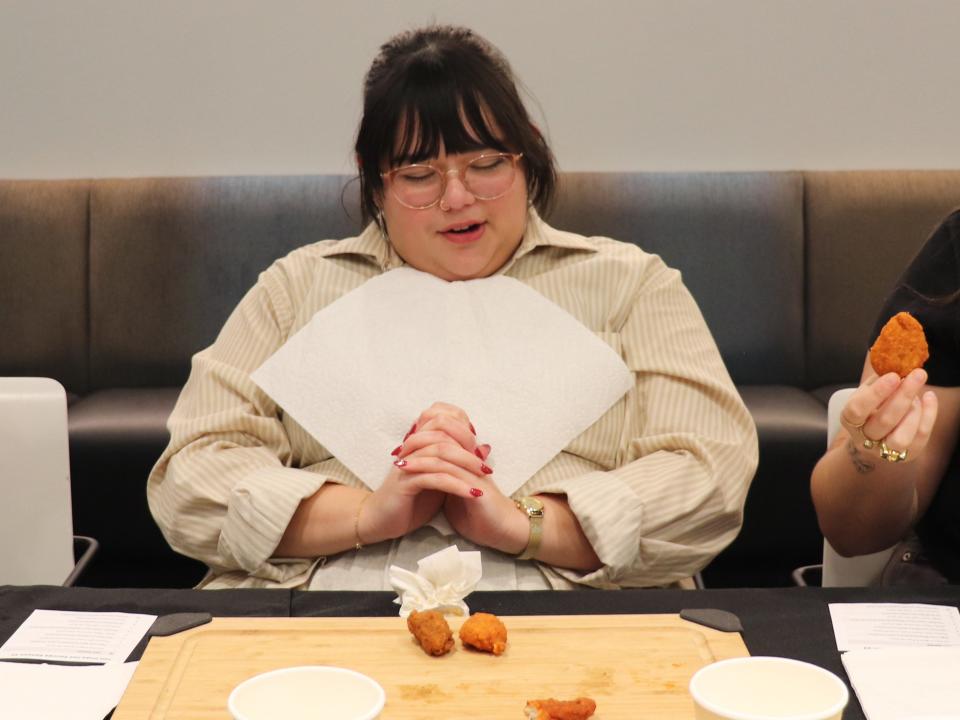 Insider reporter Libby Torres looking at a tray of chicken wings.