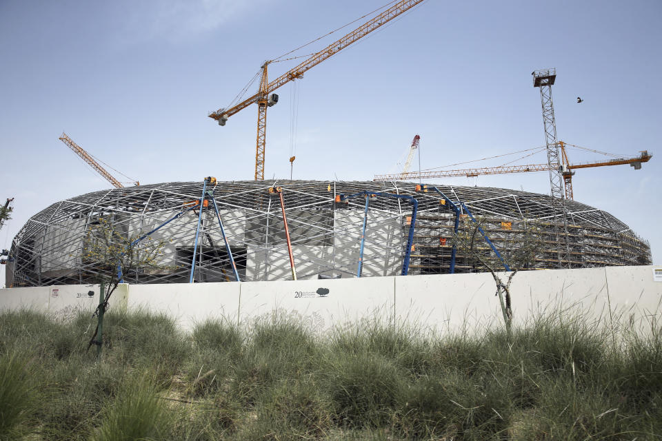 In this Friday, April 26, 2019 photo, cranes surround Qatar Foundation Stadium, an open cooled stadium with a 45,350-seat capacity. It is located in the middle of several university campuses at the Qatar Foundation's Education City in Doha, Qatar. Construction teams are working around the clock to complete eight stadiums ahead of the 2022 World Cup. (AP Photo/Kamran Jebreili)