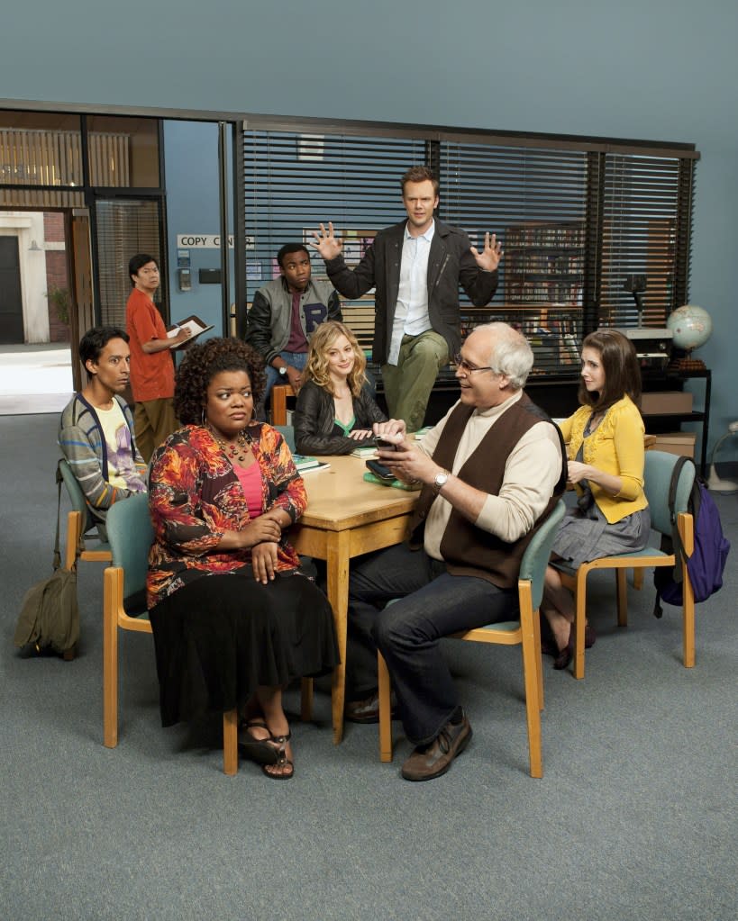 Ken Jeong, Donald Glover, Joel McHale (standing), Danny Pudi, Gillian Jacobs, Alison Brie, Yvette Nicole Brown and Chevy Chase (foreground, in vest) on the set of “Community.” ©NBC/Courtesy Everett Collection