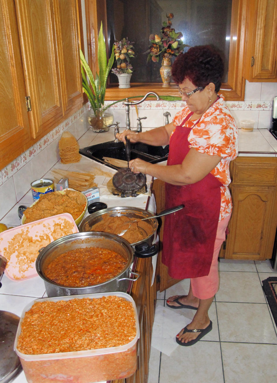 Hilda Vasquez makes tamales in her kitchen in Edinburg, Texas on Wednesday, Dec. 4, 2013.Vasquez raised the $680 for her U.S. citizenship application by selling batches of homemade tamales at South Texas offices. Immigration advocates are concerned comprehensive immigration reform proposals, which could more than triple the cost of legalization and citizenship for those illegally in the country, will make the financial hurdles almost impassable. (AP Photo/Christopher Sherman)