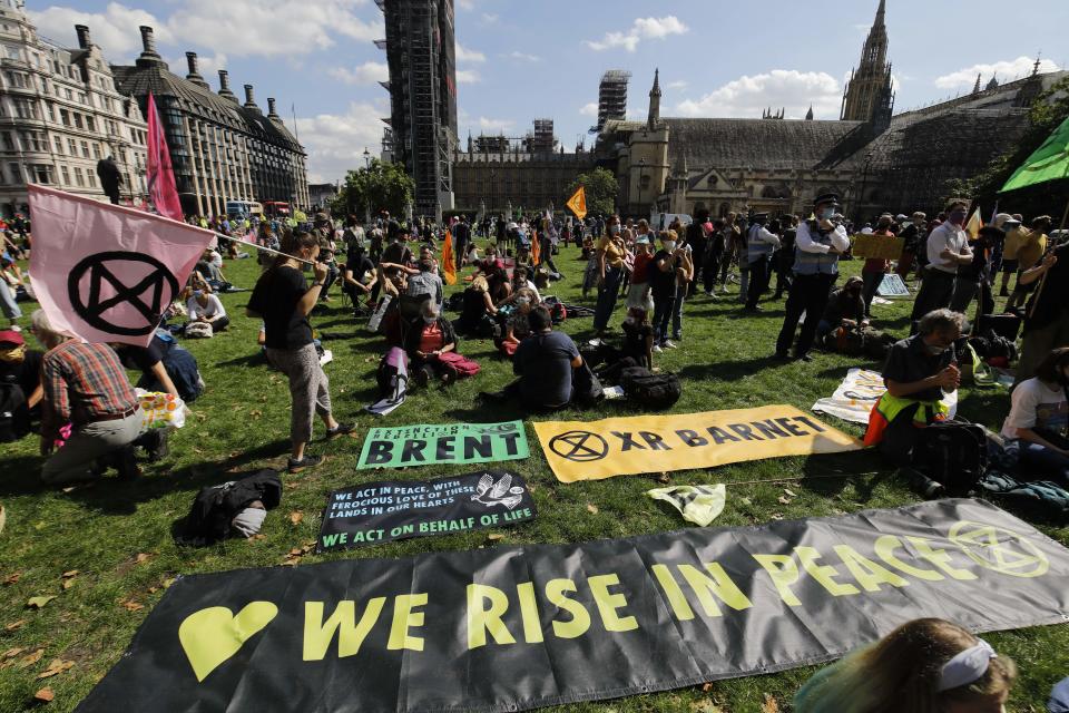 Activists from the climate protest group Extinction Rebellion march set up their banners on the Green in Parliament Square in central London on September 1, 2020 as they start their new season of "mass rebellions". - Climate protest group Extinction Rebellion will target Britain's parliament as part of "mass rebellions" starting from September 1. Other actions will take place around the country. (Photo by Tolga AKMEN / AFP) (Photo by TOLGA AKMEN/AFP via Getty Images)