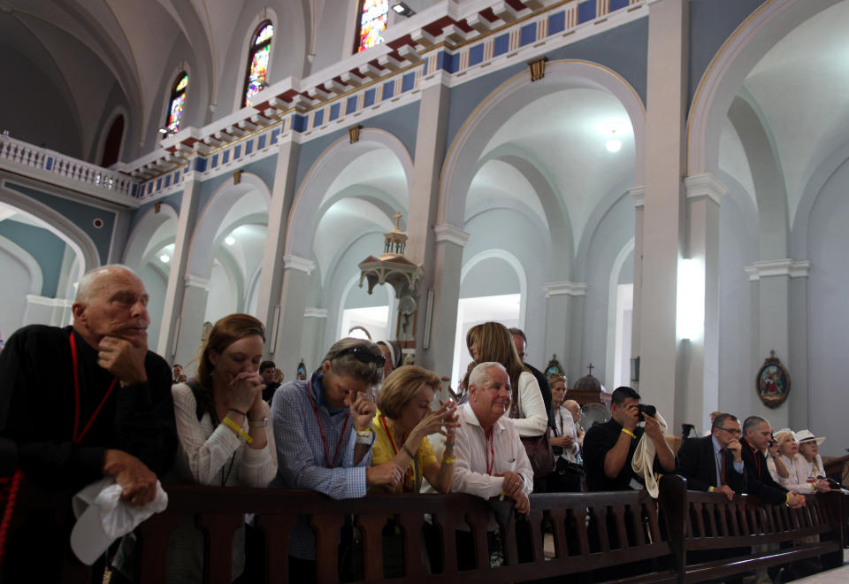 American pilgrims, mostly Cuban-Americans, pray at the Virgen del Cobre Church in Santiago de Cuba, Cuba, Monday March 26, 2012. More than 300 Cuban-Americans and other pilgrims have arrived in Cuba for Pope Benedict XVI's visit on a trip led by Miami Archbishop Thomas Wenski.(AP Photo/Esteban Felix)