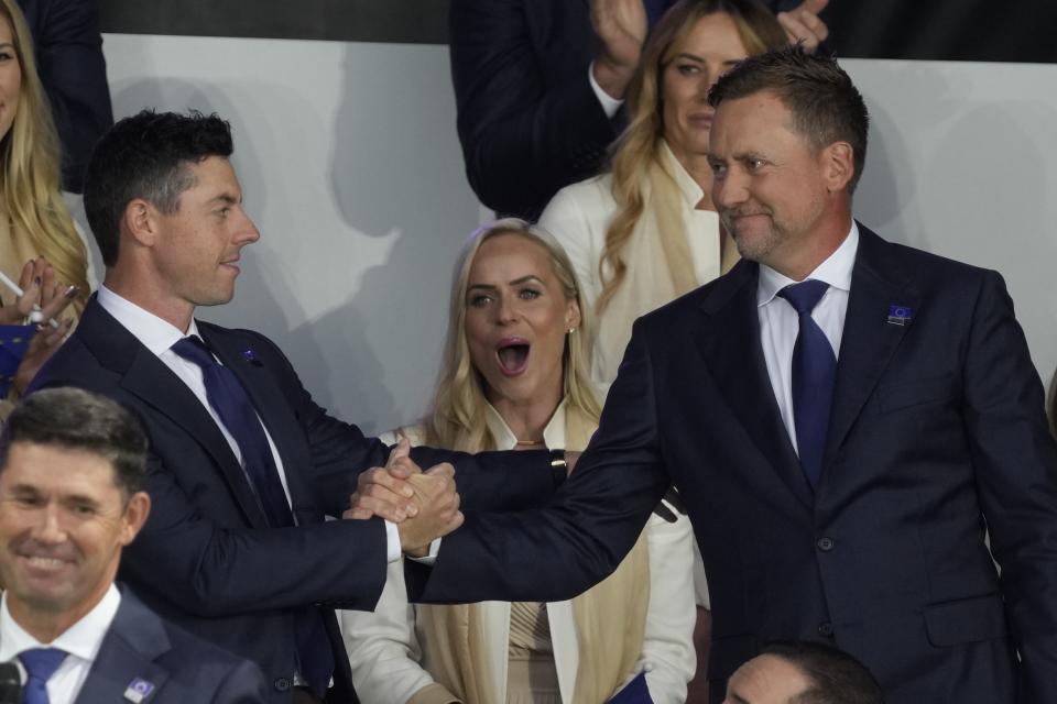 Team Europe's Rory McIlroy shakes hands with Team Europe's Ian Poulter after it was announced they would play together in Friday's foursomes during the opening ceremony for the Ryder Cup at the Whistling Straits Golf Course Thursday, Sept. 23, 2021, in Sheboygan, Wis. (AP Photo/Charlie Neibergall)