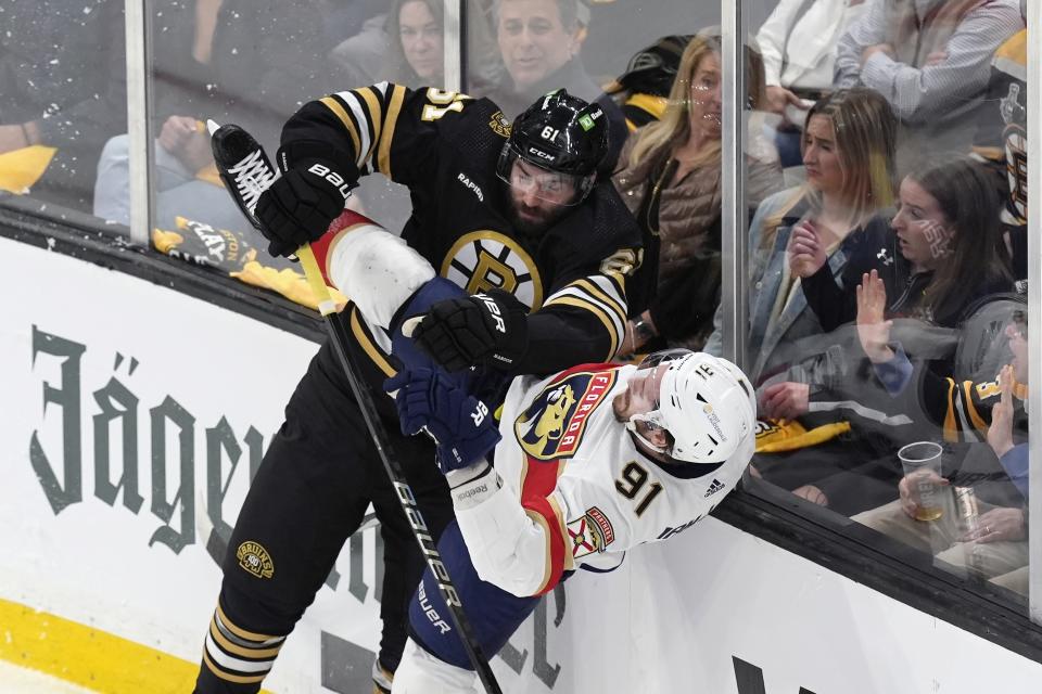Boston Bruins' Pat Maroon (61) checks Florida Panthers' Oliver Ekman-Larsson (91) during the first period in Game 3 of an NHL hockey Stanley Cup second-round playoff series Friday, May 10, 2024, in Boston. (AP Photo/Michael Dwyer)