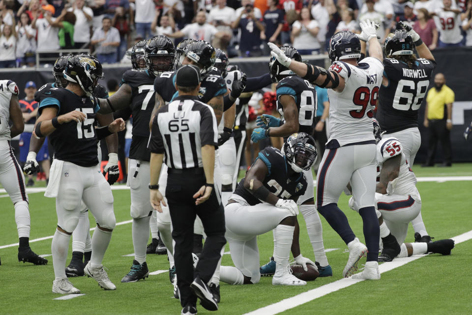 Houston Texans defensive end J.J. Watt (99) signals after Jacksonville Jaguars running back Leonard Fournette (27) was held short of the goal line on a two-point conversion attempt during the second half of an NFL football game Sunday, Sept. 15, 2019, in Houston. (AP Photo/David J. Phillip)