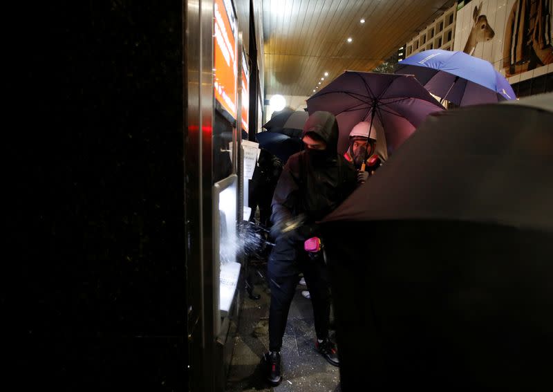 An anti-government protester vandalizes an ATM during a demonstration on New Year's Day to call for better governance and democratic reforms in Hong Kong