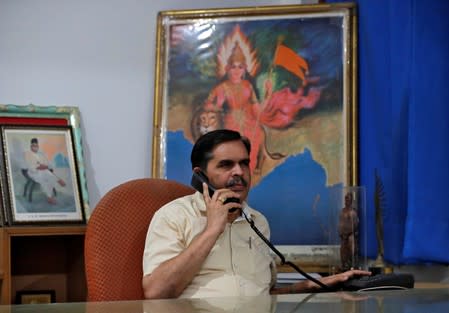 Ashwani Mahajan, chief of the Hindu nationalist Rashtriya Swayamsevak Sangh's (RSS) economic group Swadeshi Jagran Manch (SJM), poses for a photograph as he holds a phone inside his office in New Delhi