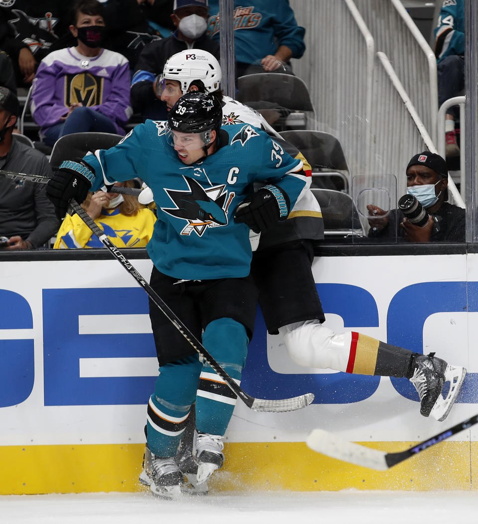 San Jose Sharks center Logan Couture (39) checks Vegas Golden Knights defenseman Nicolas Hague (14) into the boards in the first period of a preseason NHL hockey game in San Jose, Calif., Saturday, Oct. 9, 2021. (AP Photo/Josie Lepe)