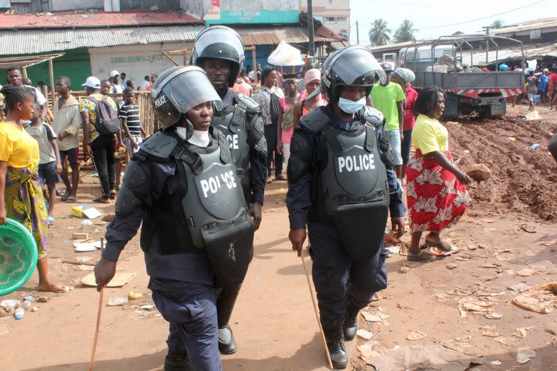 Police officers chase shoppers to clear the streets of the Red Light market on first day of lockdown to stop the spread of the coronavirus disease (COVID-19) in Monrovia