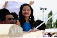 Child actress Xyriel Manabat throws posters to the crowd as the float of the movie, Sisterekas makes its way at the 2012 Metro Manila Film Festival Parade of Stars on 23 December 2012. (Angela Galia/NPPA Images)