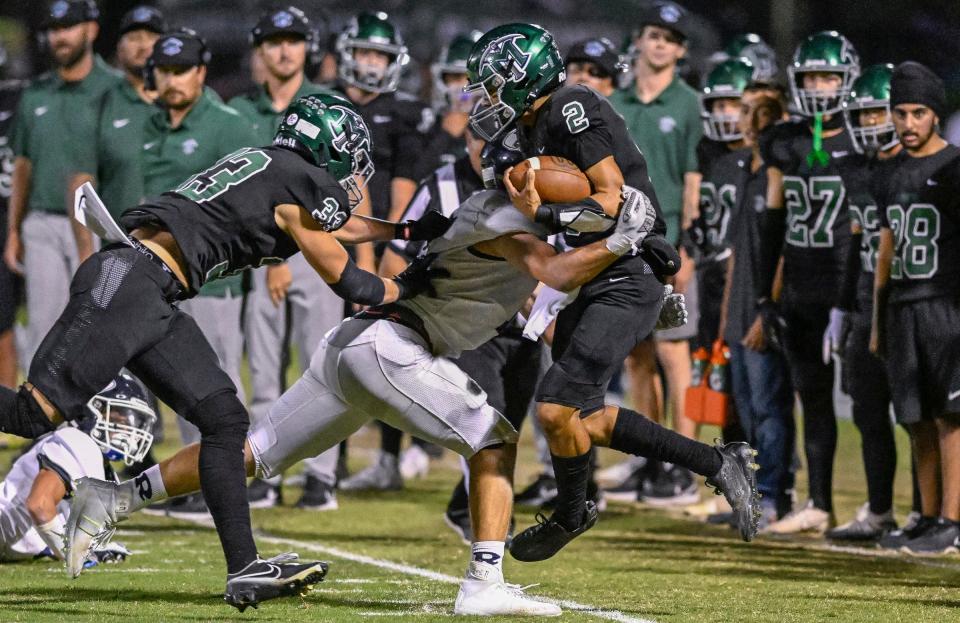 Redwood's Chase Dempsey lifts El Diamante's Joseph Trevizo out of bounds in an East Yosemite League high school football game Friday, September 29, 2023.