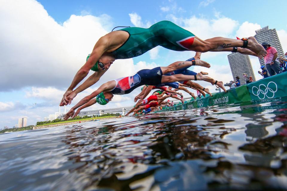 <p>Athletes compete in the men's individual triathlon competition during the Tokyo 2020 Olympic Games at the Odaiba Marine Park in Tokyo on July 26, 2021. (Photo by ANTONIO BRONIC / various sources / AFP)</p> 