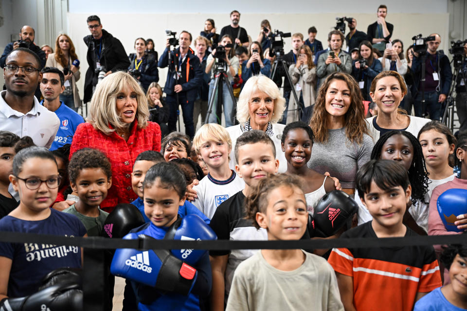 Britain's Queen Camilla, center, poses with French President Emmanuel Macron's wife Brigitte Macron, left, and children during a visit to a gymnasium, Thursday, Sept. 21, 2023 in Saint-Denis, outside Paris. On the second day of his state visit to France, King Charles met with sports groups in the northern suburbs of Paris and was scheduled to pay a visit to fire-damaged Notre-Dame cathedral. (Bertrand Guay, Pool via AP)