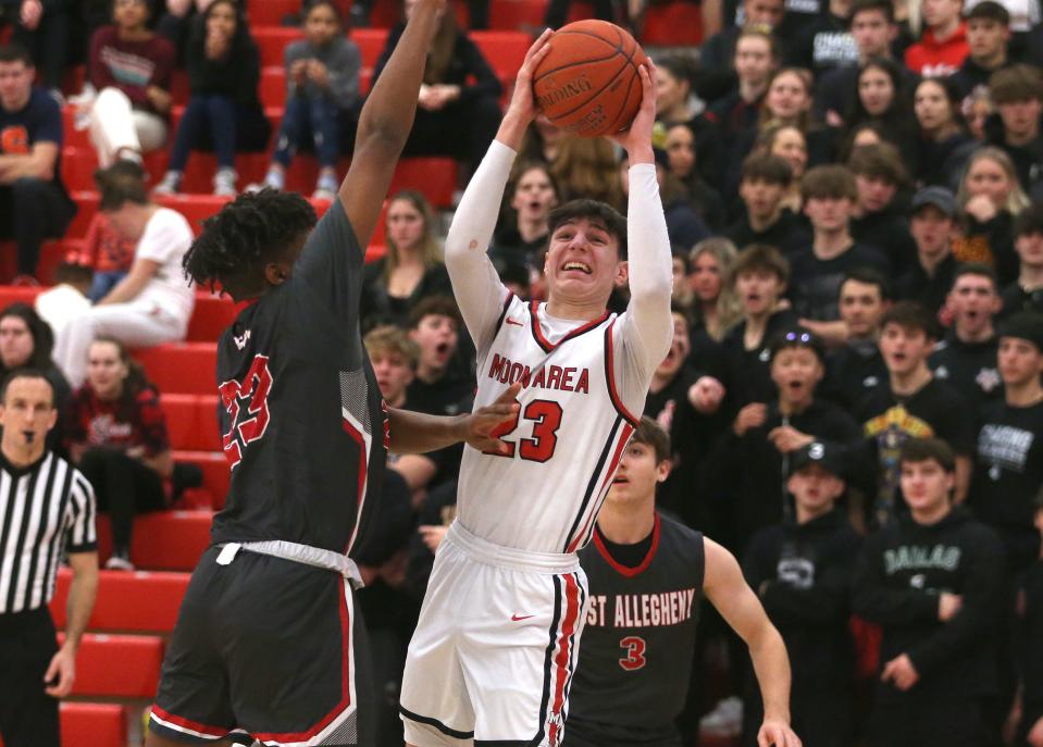 Moon's Michael Santicola (23) attempts a layup while being guarded by West Allegheny's Brandon Bell (23) during the first half Tuesday night at Moon Area High School.