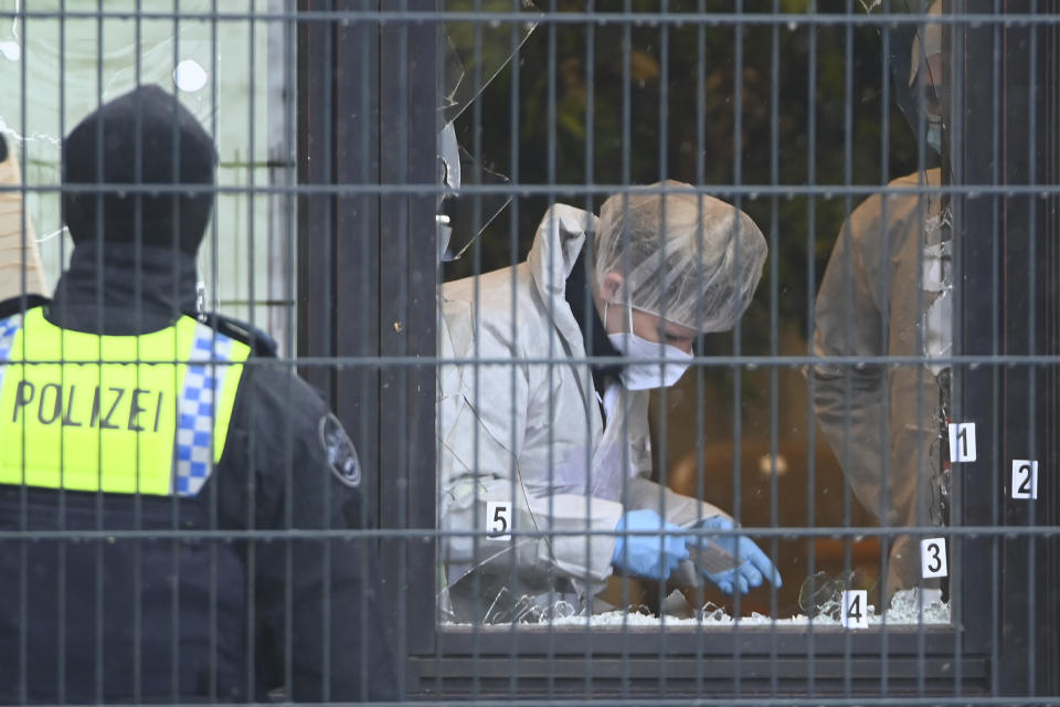 Investigators and forensic experts stand outside a Jehovah's Witness building in Hamburg, Germany Friday, March 10, 2023. Shots were fired inside the building used by Jehovah's Witnesses in the northern German city of Hamburg on Thursday evening, with multiple people killed and wounded, police said. (Jonas Walzberg/dpa via AP)