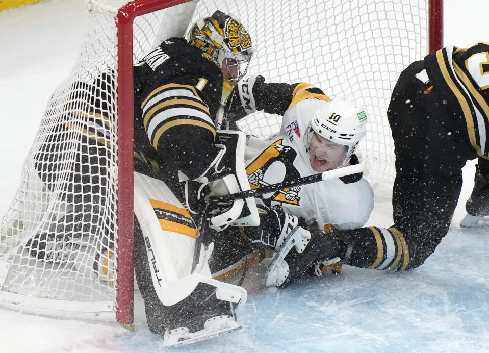 Pittsburgh Penguins left wing Drew O'Connor (10) collides with Boston Bruins goaltender Jeremy Swayman (1) as they slide into the net after O'Connor attempted to score in the first period of an NHL hockey game, Thursday, Jan. 4, 2024, in Boston. (AP Photo/Steven Senne)