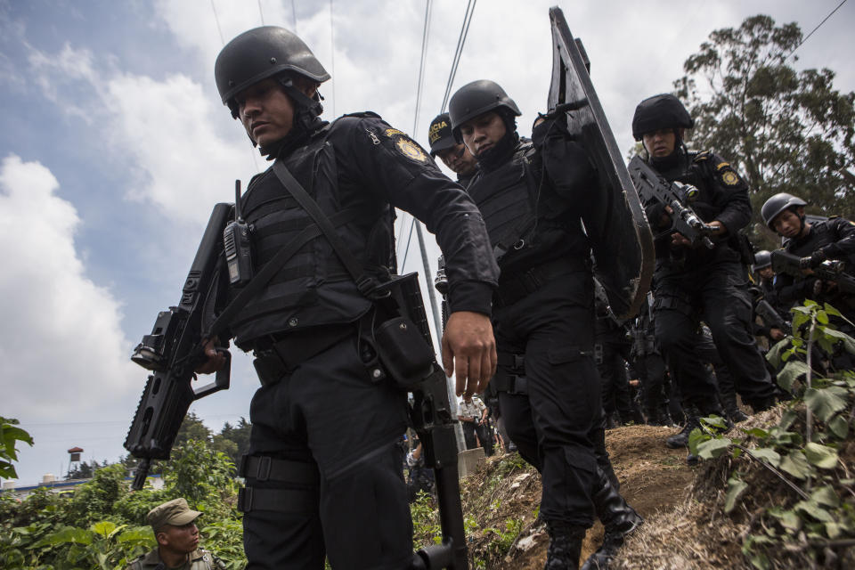 Special task force police take position outside the Pavon Rehabilitation Model Farm after a shooting inside the jail in Fraijanes, Guatemala, Tuesday, May 7, 2019. At least three people were killed and 10 people were wounded in the shooting, authorities said. (AP Photo/Oliver De Ros)