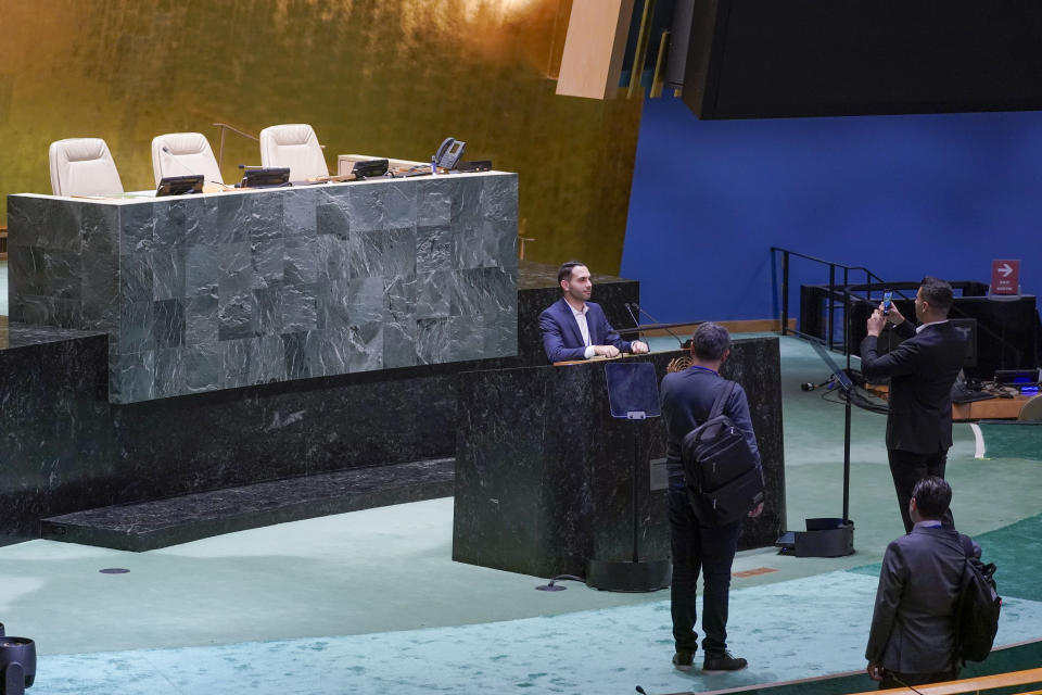 Visitors to the United Nations headquarters take photos at the General Assembly speaker's podium ahead of the General Assembly, Friday, Sept. 16, 2022. (AP Photo/Mary Altaffer)