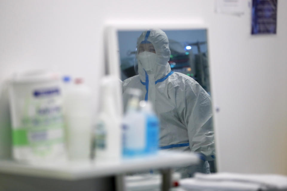 A healthcare worker is reflected in a mirror inside a COVID-19 Intensive Care Unit at the military hospital in Lisbon, Wednesday, Jan. 27, 2021. The military hospital is expanding it's number of beds available to take COVID-19 patients from the National Health Service. Portugal is reporting new daily records of COVID-19 deaths and hospitalizations as a recent pandemic surge continues unabated. (AP Photo/Armando Franca)