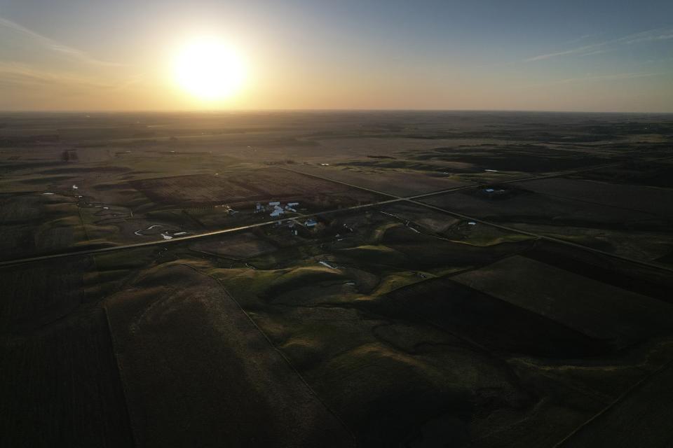 The sun sets on a rural farm just outside of Pipestone, Minn., on Wednesday, May 3, 2023. (AP Photo/Jessie Wardarski)