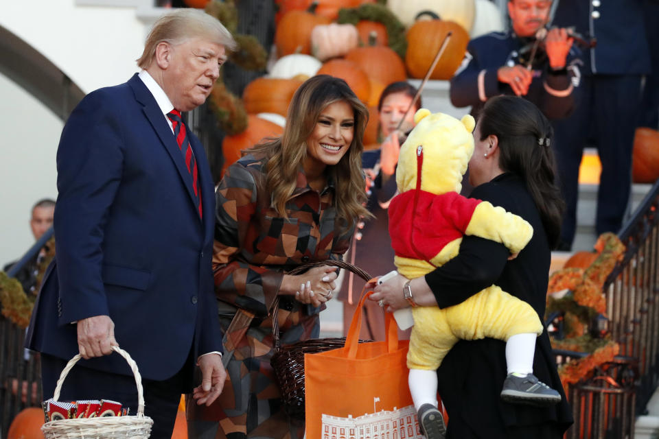 President Donald Trump and first lady Melania Trump give candy to children during a Halloween trick-or-treat event on the South Lawn of the White House which is decorated for Halloween, Monday, Oct. 28, 2019, in Washington. (AP Photo/Alex Brandon)