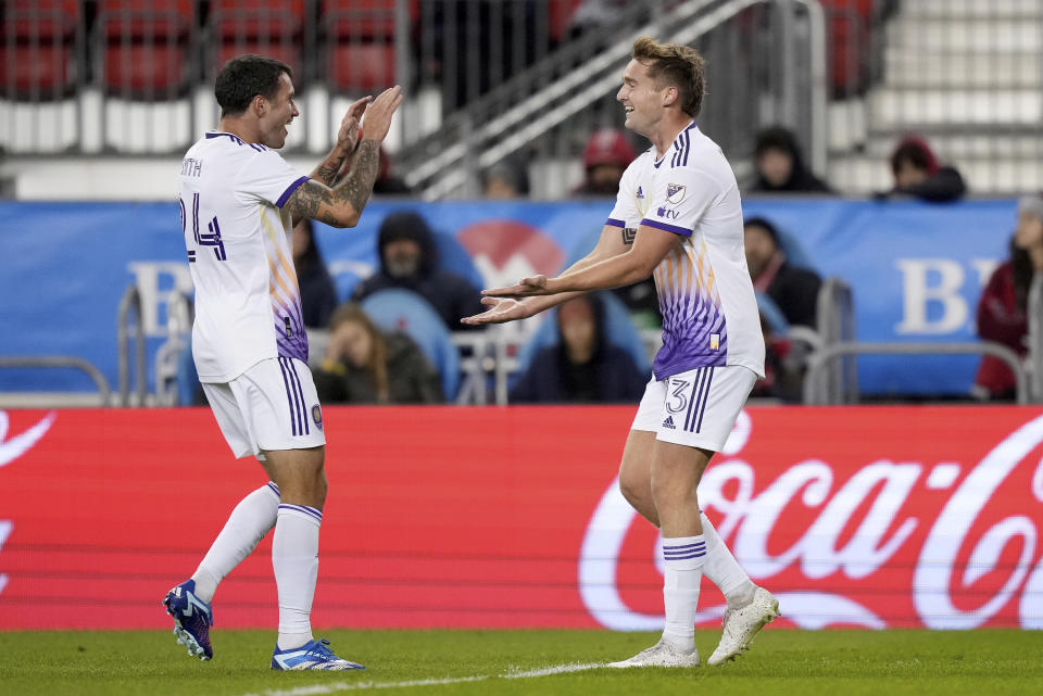 Orlando City forward Duncan McGuire, right, celebrates his second goal of the game with teammate Kyle Smith (24) during the second half of an MLS soccer match against Toronto FC in Toronto on Saturday, Oct. 21, 2023. (Nathan Denette/The Canadian Press via AP)