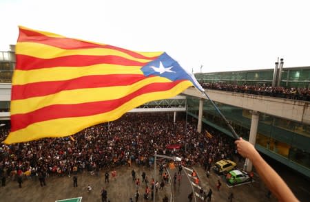 A protester waves an Estelada (Catalan separatist flag) during a demonstration outside the airport in Barcelona