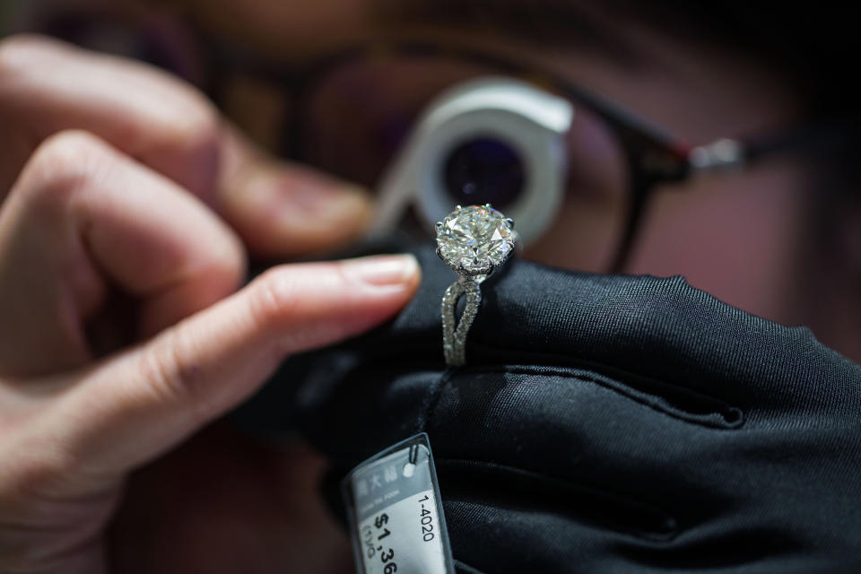 An employee inspects a diamond ring inside a Chow Tai Fook Jewellery Group Ltd. store in the Central district of Hong Kong, China, on Friday, Jan. 20, 2017. Chow Tai Fook, the world's largest jewelry chain, last year launched the first of a line of mainland shops selling lower-priced jewelry, with average prices of 2,000 yuan ($291), about a third the prices at its flagship stores. Photographer: Billy H.C. Kwok/Bloomberg via Getty Images