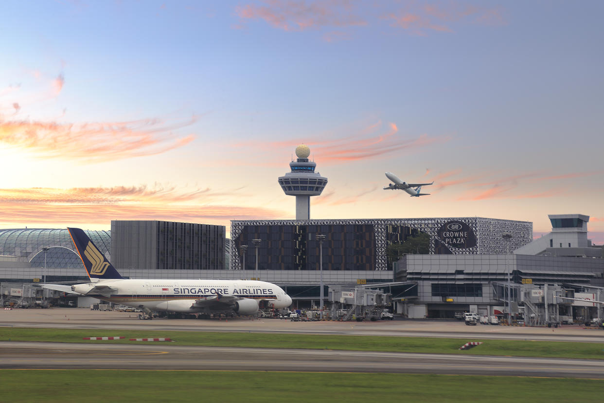 Singapore Changi Airport runway and Air traffic control tower at background. The photo was taken at terminal 2 of Singapore Changi Airport with air carrier at sight. Asia.