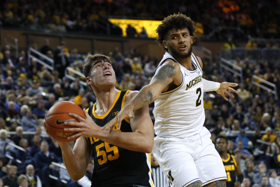 Michigan forward Isaiah Livers (2) fouls Iowa center Luka Garza (55) in the second half of an NCAA college basketball game in Ann Arbor, Mich., Friday, Dec. 6, 2019. (AP Photo/Paul Sancya)