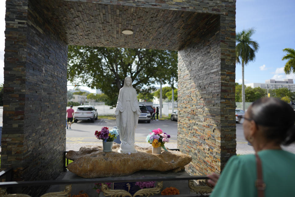 A parishioner visits a statue of the Virgin Mary, outside St. Agatha Catholic Church, which has become the spiritual home of the growing Nicaraguan diaspora, Sunday, Nov. 5, 2023, in Miami. For the auxiliary bishop of Managua, his fellow priests and many worshippers who have had to flee or were exiled from Nicaragua recently, the Sunday afternoon Mass at the Miami parish is not only a way to find solace in community, but also to keep pushing back against the Ortega regime's violent suppression of all critics, including many Catholic leaders. (AP Photo/Rebecca Blackwell)