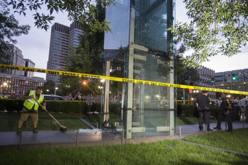 A worker cleans up glass at the Boston memorial. (Getty Images)